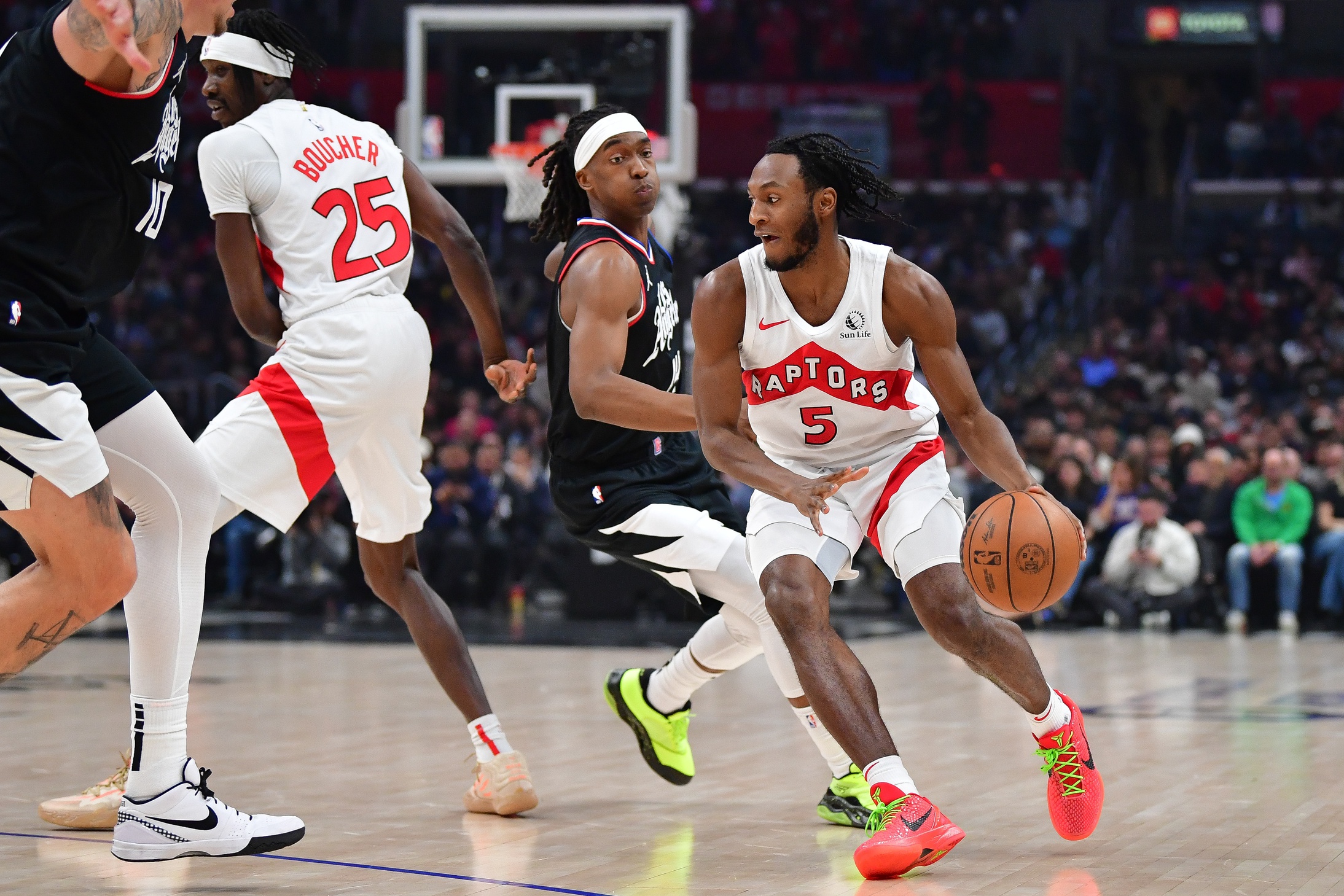 Jan 10, 2024; Los Angeles, California, USA; Toronto Raptors guard Immanuel Quickley (5) moves the ball as forward Chris Boucher (25) provides coverage against Los Angeles Clippers guard Terance Mann (14) during the first half at Crypto.com Arena. Mandatory Credit: Gary A. Vasquez-USA TODAY Sports