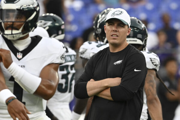 Aug 9, 2024; Baltimore, Maryland, USA; Philadelphia Eagles offensive coordinator Kellen Moore looks on as quarterback Jalen Hurts (1) throws before a preseason game against the Baltimore Ravens at M&T Bank Stadium. Mandatory Credit: Tommy Gilligan-USA TODAY Sports