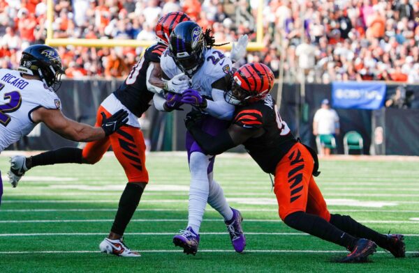 Cincinnati Bengals cornerback DJ Turner II (20), left and defensive end Myles Murphy (99) take down Baltimore Ravens running back Derrick Henry (22) during the 4th quarter Sunday October 6, 2024 at Payor Stadium. The Bengals lost to Baltimore Ravens 41-38 in overtime.