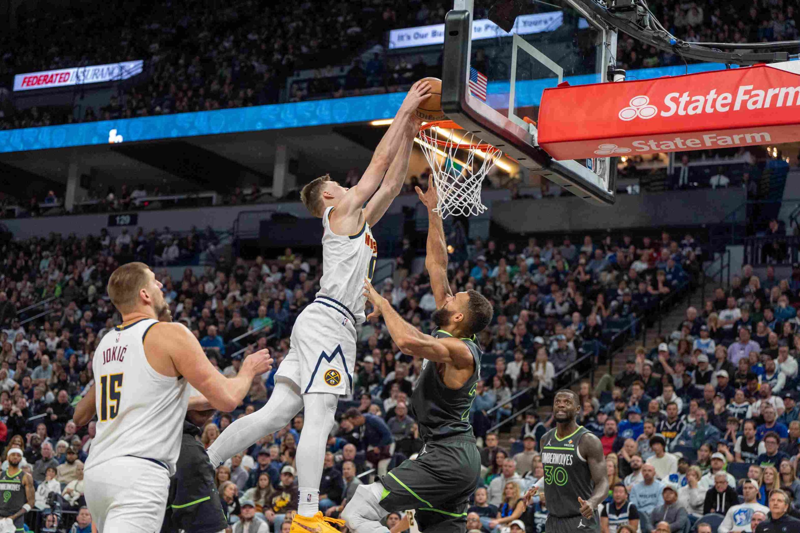 Nov 1, 2024; Minneapolis, Minnesota, USA; Denver Nuggets guard Christian Braun (0) dunks over Minnesota Timberwolves center Rudy Gobert (27) both players would pick up flagrant fouls when a fight breaks out after the play in the fourth quarter at Target Center. Mandatory Credit: Matt Blewett-Imagn Images