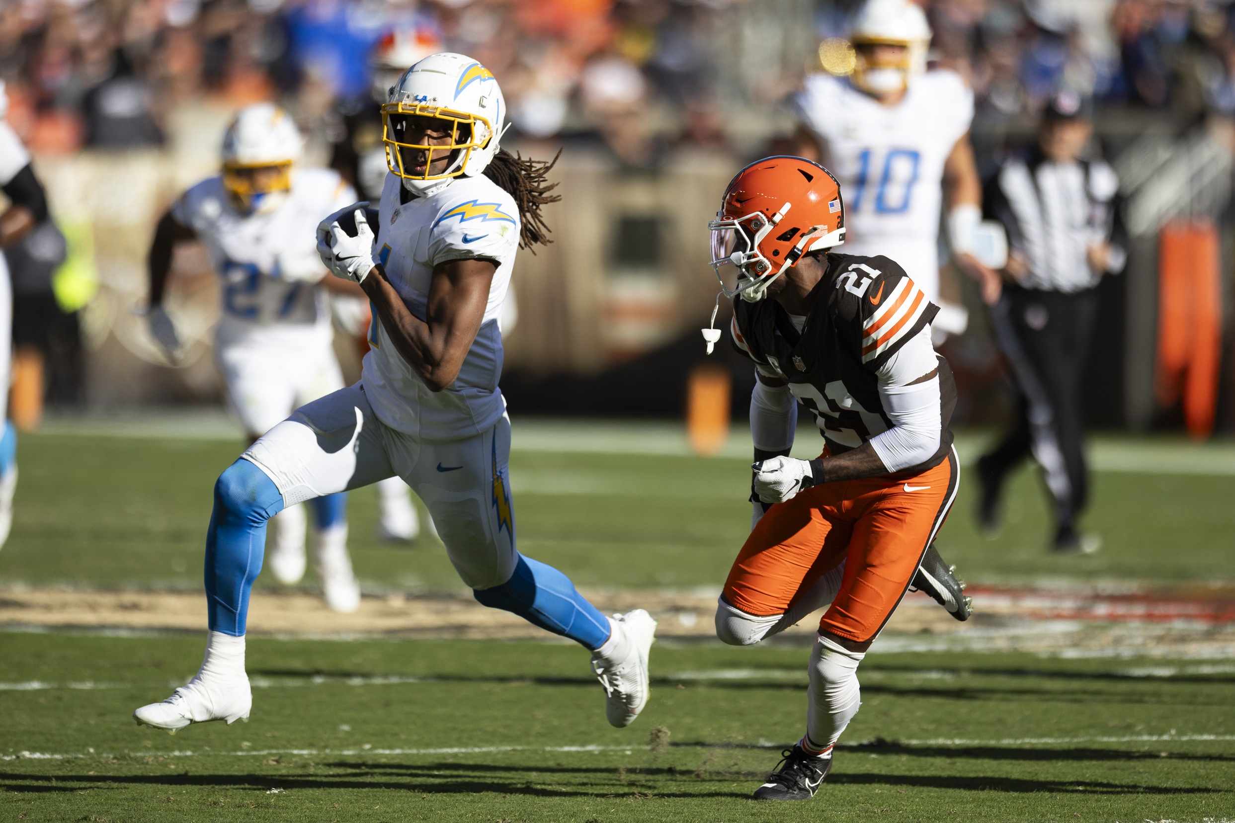 Nov 3, 2024; Cleveland, Ohio, USA; Los Angeles Chargers wide receiver Quentin Johnston (1) runs the ball as Cleveland Browns cornerback Denzel Ward (21) chases him during the second quarter at Huntington Bank Field. Mandatory Credit: Scott Galvin-Imagn Images