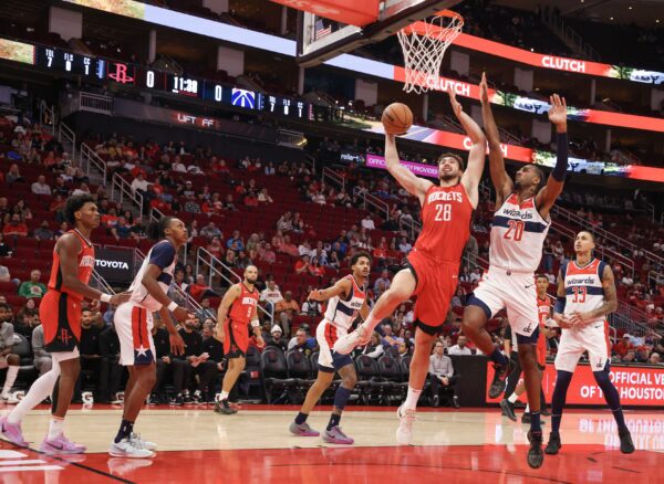 Nov 11, 2024; Houston, Texas, USA; Houston Rockets center Alperen Sengun (28) scores against Washington Wizards forward Alexandre Sarr (20) in the first quarter at Toyota Center. Mandatory Credit: Thomas Shea-Imagn Images