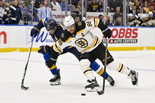 Nov 12, 2024; St. Louis, Missouri, USA; Boston Bruins right wing David Pastrnak (88) skates against St. Louis Blues defenseman Pierre-Olivier Joseph (77) during the third period at Enterprise Center. Mandatory Credit: Jeff Curry-Imagn Images